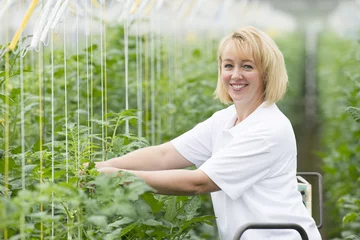 Fototapeten Blond woman forty years old working in a greenhouse © Frank