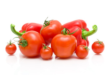 ripe tomatoes of different varieties and red pepper on a white b