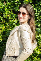 Happy young woman surrounded by green leaves