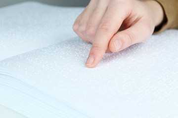 Blind woman read book written in Braille