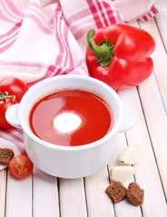 Tasty tomato soup and vegetables on wooden table