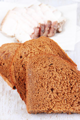 Slices of bread and lard on cutting board close up