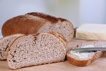 Rye bread with butter on table on bright background