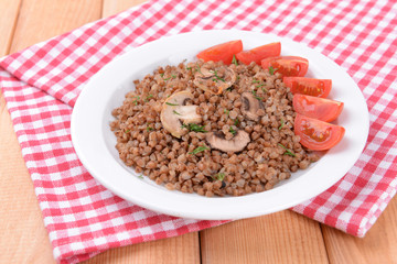 Boiled buckwheat on plate on table close-up
