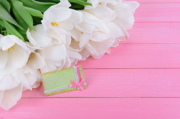 Beautiful bouquet of white tulips on pink background