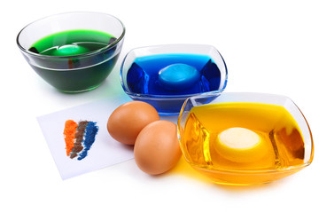 Bowls with paint for Easter eggs and eggs, isolated on white