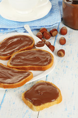 Bread with sweet chocolate hazelnut spread on plate on table