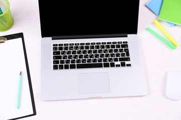 Office workplace with open laptop on wooden desk