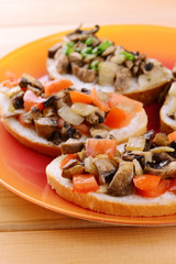 Delicious bruschetta with mushrooms on plate on table close-up