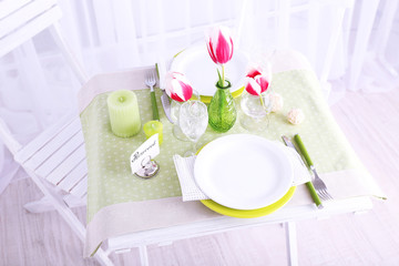 New table and chairs with place settings on light background