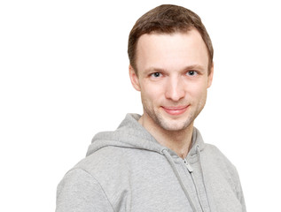 Obraz premium Smiling young Caucasian man in gray sports jacket with hood