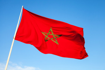Fototapeta na wymiar National flag of Morocco above blue sky