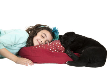 young girl sleeping with black lab puppy