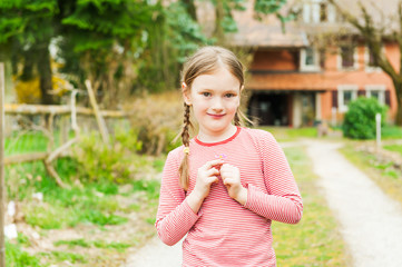 Adorable little girl standing against beautiful house