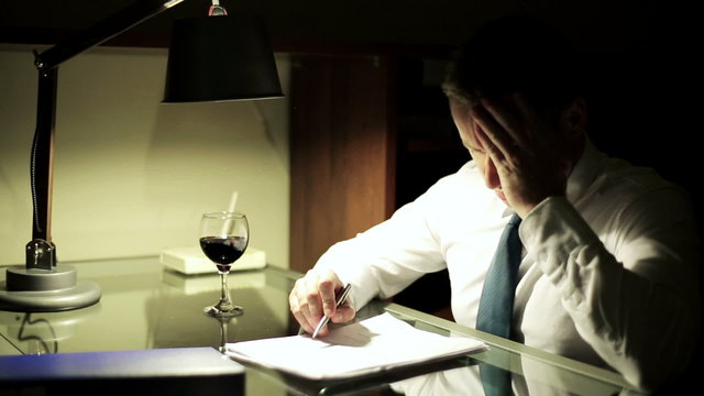 Businessman have headache at night work by the table.