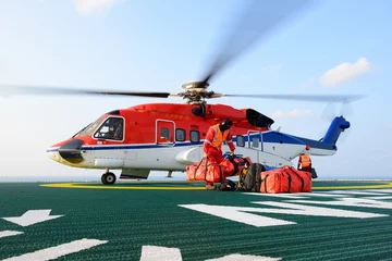 Foto auf Acrylglas Hubschrauber Der Hubschrauberlandeoffizier verlädt das Gepäck zum Hubschrauber um