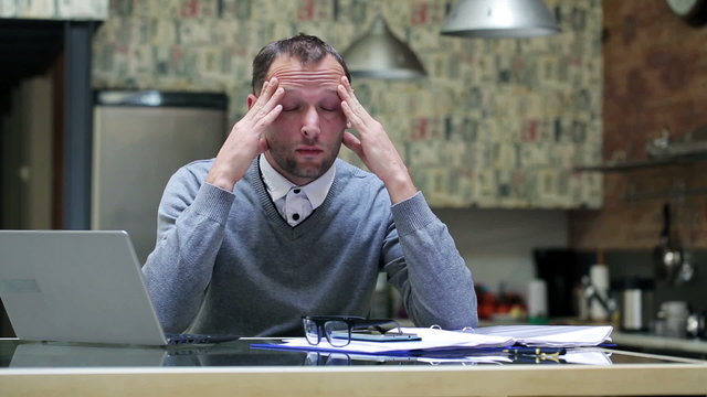 Businessman heave headache and work on laptop 