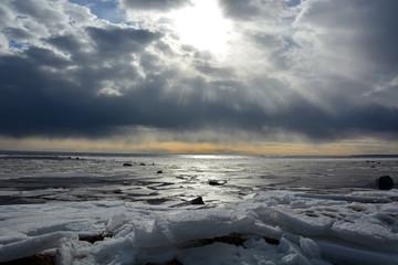 Sun through the stormy clouds at the frozen sea