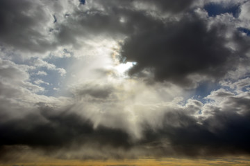 Obraz na płótnie Canvas Sun through the stormy clouds