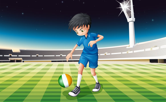 A boy at the field using the ball with the flag of Ireland