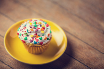 Cream cake with plate on a wooden table.