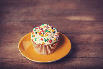 Cream cake with plate on a wooden table.