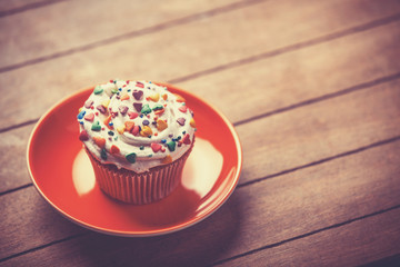 Cream cake with plate on a wooden table.