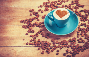 Cup of сoffee with shape heart on a wooden table.