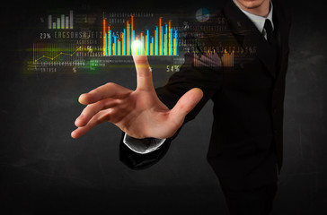 Young business person touching colorful charts and diagrams