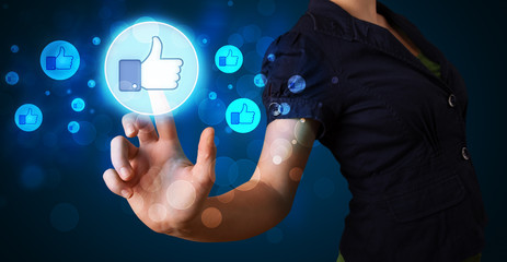 Young businesswoman pressing thumbs up button on modern social n