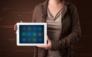 Woman holding a white tablet with blurry apps