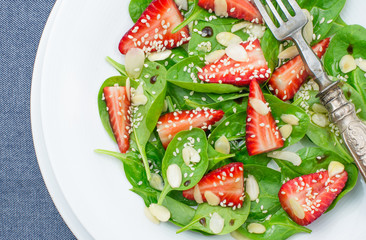 Spinach and strawberry salad closeup, top view