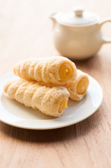 Cream-filled pastry roll on the wood board