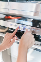 Hand moving the timer knob on the oven