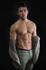 Fototapeta premium Young muscular man with jacket pulled down on naked torso