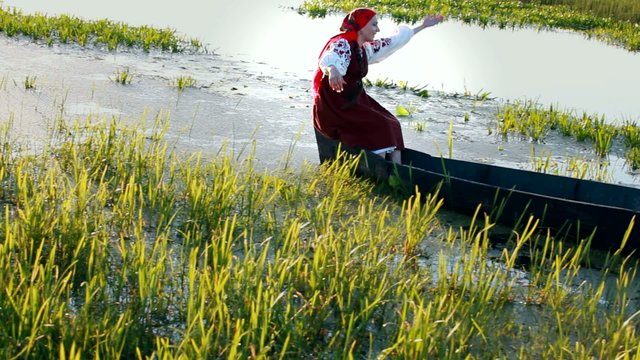 Красивая девушка плывет на лодке и поет