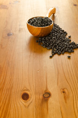 Black beans on wooden background