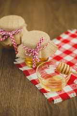 Two jars of honey and honeycombs isolated on white