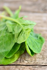 Fototapeta premium raw green spinach on wooden table