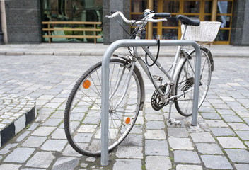 Old, used urban grey bicycle parked in the street.