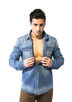 Latin young man opening denim shirt on naked chest