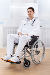Handicapped Doctor Sitting On Wheel Chair In Hospital
