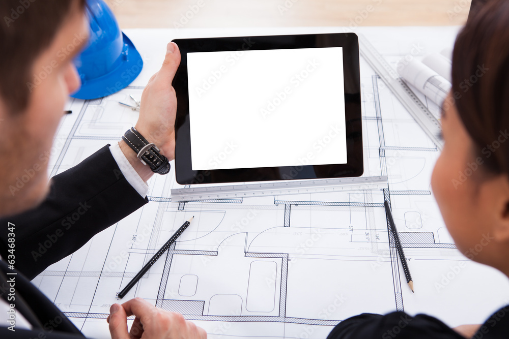 Poster architects with digital tablet working on blueprint