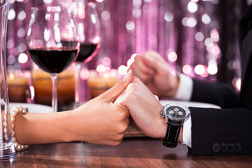 Couple Holding Each Other's Hand At Dinner