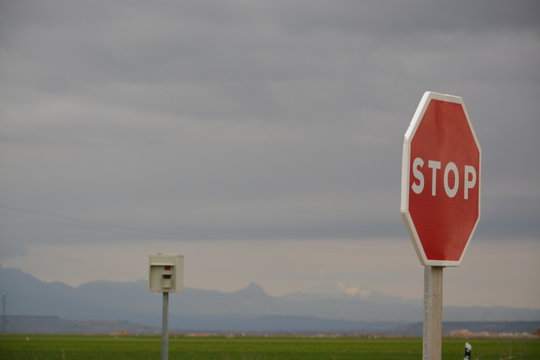 Se&ntilde;al de stop roja con radar de control de velocidad al fondo