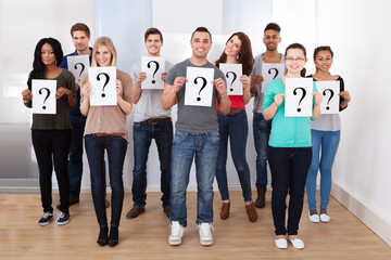 Obraz premium College Students Holding Question Mark Signs