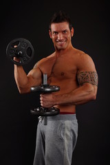 Muscular man holding dumbbell exercises and biceps muscle