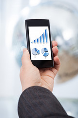 Hand Analyzing Financial Charts On Smartphone
