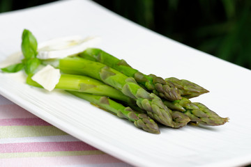Close up of fresh green asparagus with  a fresh cheese
