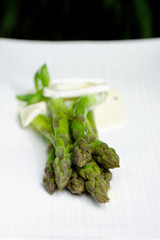 Close up of fresh green asparagus with  a fresh cheese